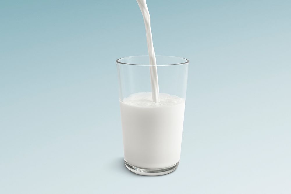 Pouring milk in glass, blue background