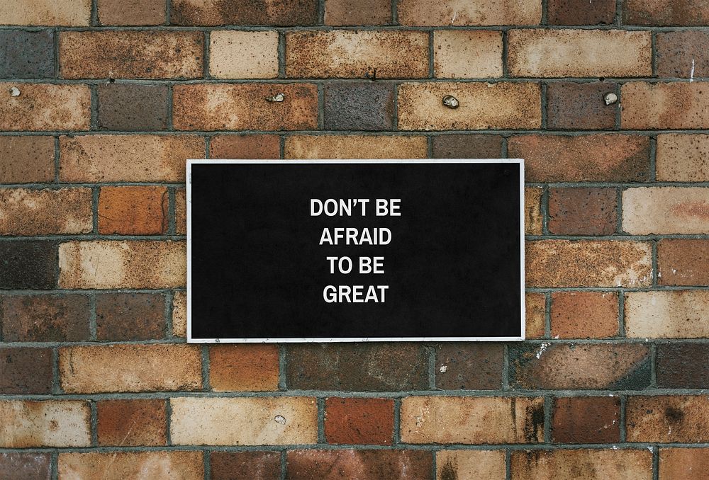 Don't be afraid to be great board mockup on a brick wall