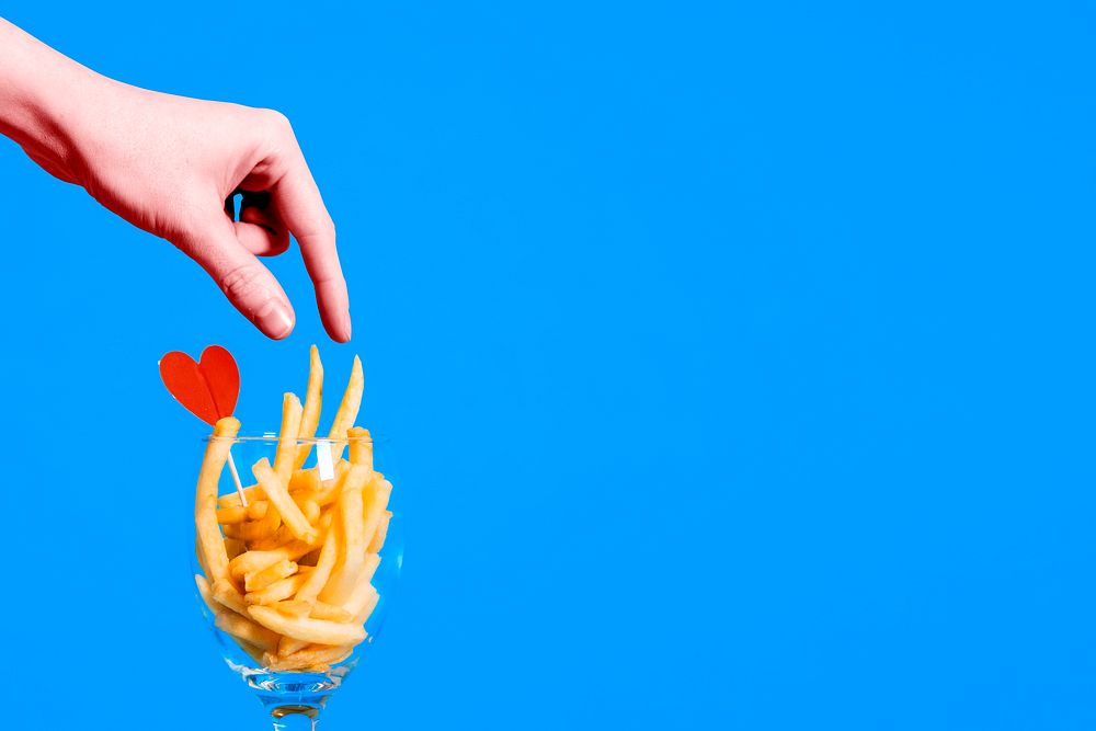Food background, hand picking up fries