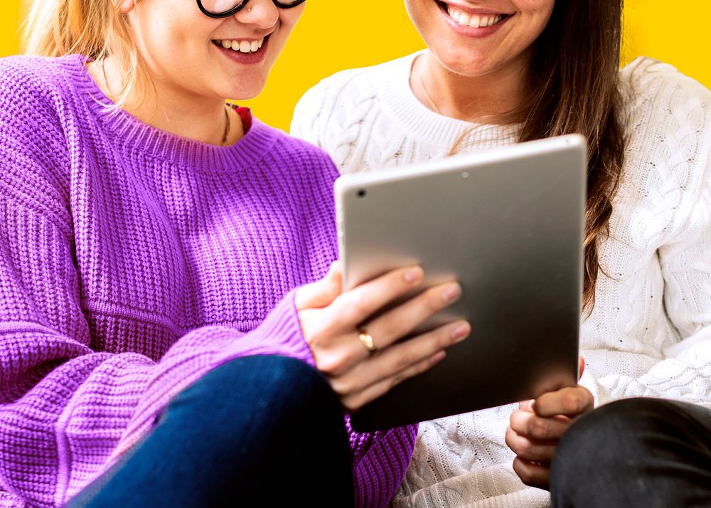 Happy women using tablet together