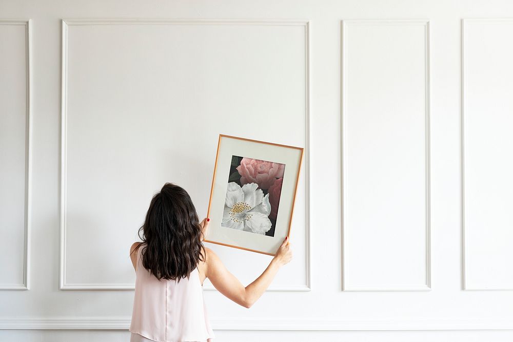 Curator hanging floral art frame mockup on the wall