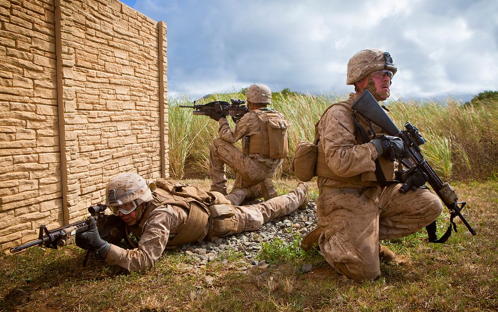 U.S. Marines assigned to India Company, 3rd Battalion, 3rd Marine Regiment, provide security outside of a compound wall…