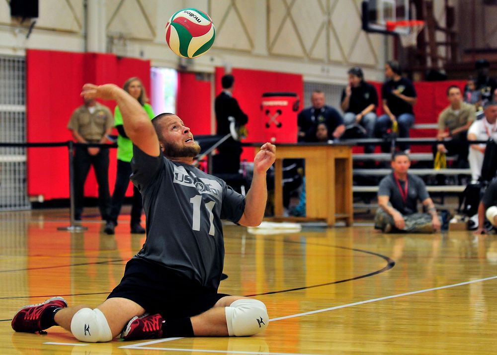 Retired U.S. Army Spc. Kyle Butcher serves during a sitting volleyball game between the U.S. Special Operations Command team…