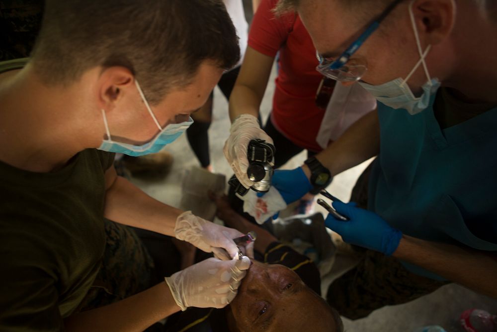 A U.S. Navy hospital corpsman, left, attached to the 3rd Medical Battalion and Filipino volunteers extract a tooth during a…