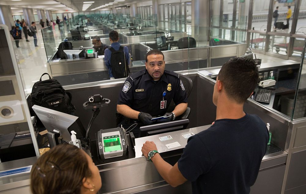 U.S. Customs and Border Protection officers screen international passengers arriving at the Dulles International Airport in…