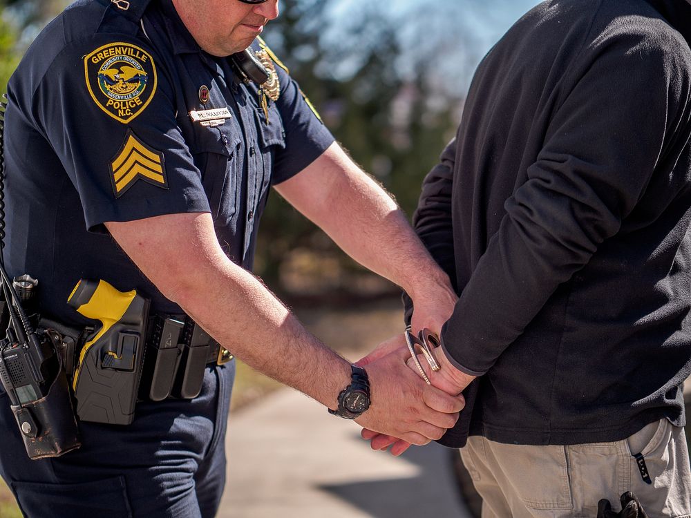 Police cuffing demonstration, Greenville, date unknown, photo by Aaron Hines.  Original public domain image from Flickr