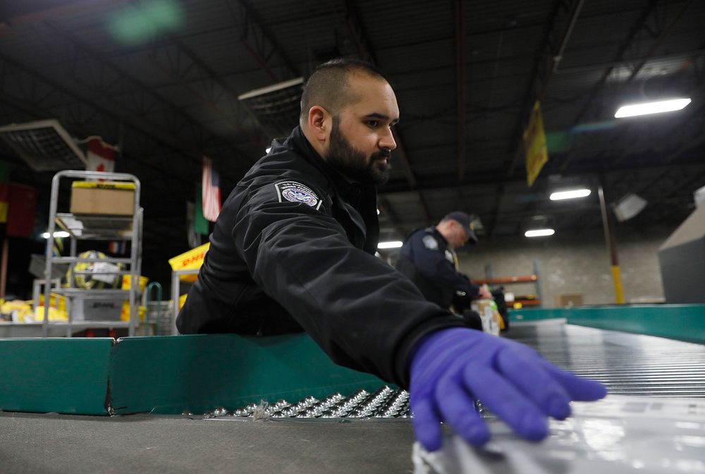 Officers with U.S. Customs and Border Protection, Office of Field Operations, screen packages for counterfeit products being…