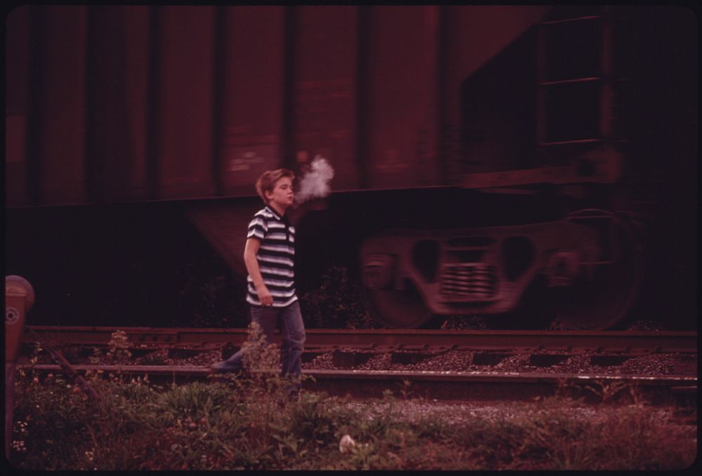 The Cool Morning Air Condenses a Boy's Breath as He Walks Along a Coal Car on His Way to School in Cumberland, Kentucky, in…