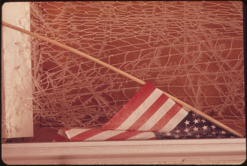 Old Flag and Frosted Window in Dock Square, the Center of Rockport. Photographer: Parks, Deborah. Original public domain…