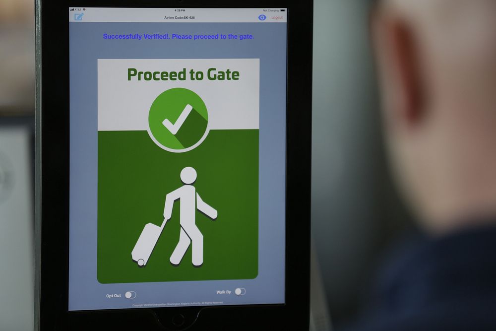 A VeriScan facial recognition tablet tells a passenger to proceed to the gate after taking a photo in the next phase of…