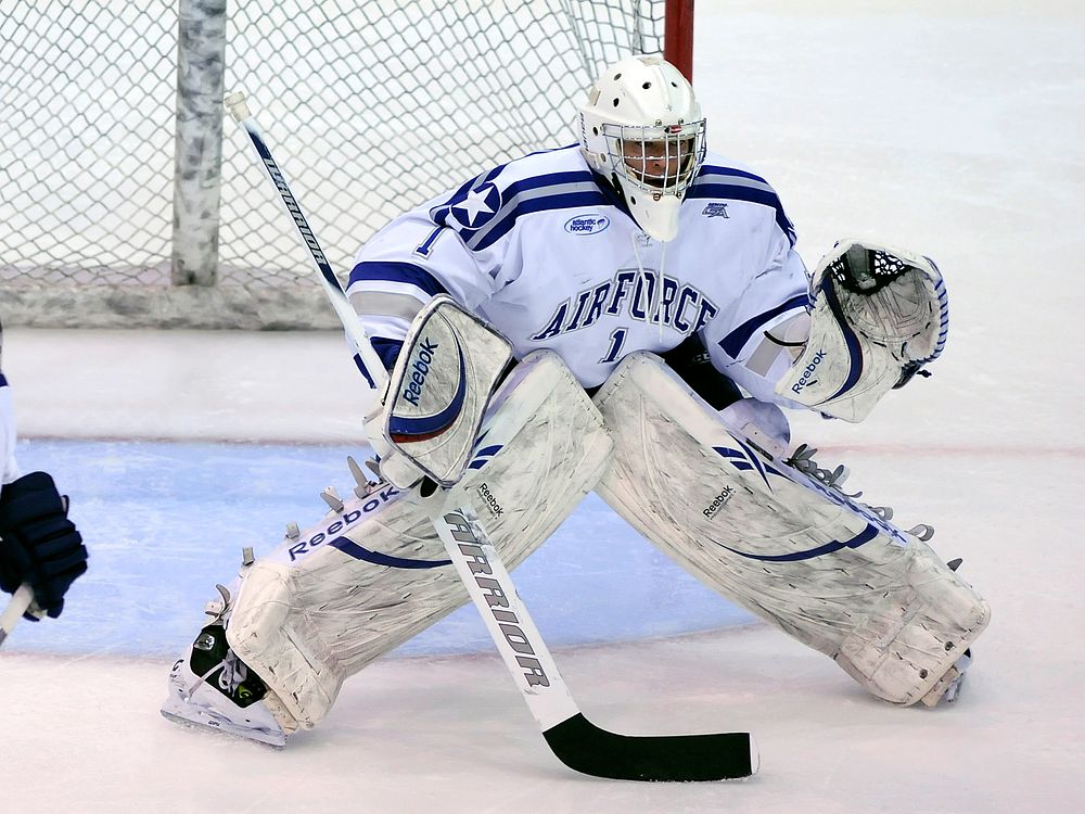 U.S. Air Force Academy Cadet Andrew Volkening, a goalie for the academy?s Falcons hockey team, protects his goal during a…