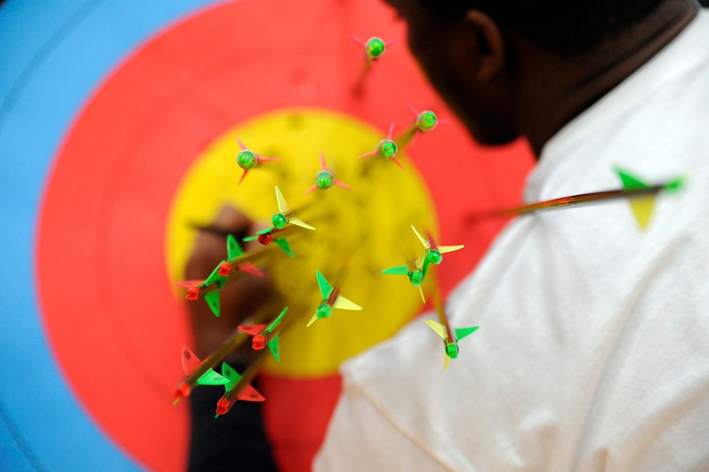 U.S. Air Force Staff Sgt. Charles Leverette marks where arrows have hit a target while scoring the archery portion of the…