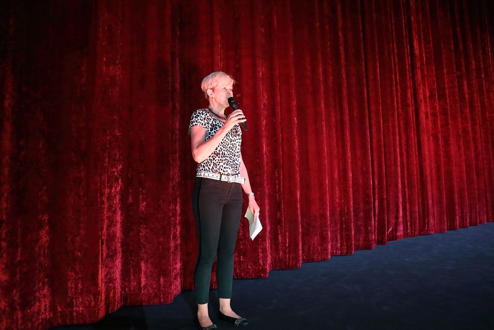 Master of ceremonies, woman on stage. Original public domain image from Flickr