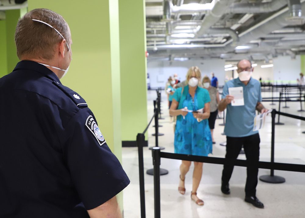 U.S. Customs and Border Protection officers wear personal protective equipment to guard against coronavirus as they…