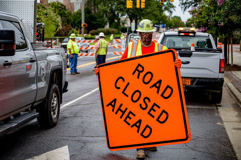 Construction workers remove barricades and signs to officially open the Evans Street and Reade Circle intersection on July…