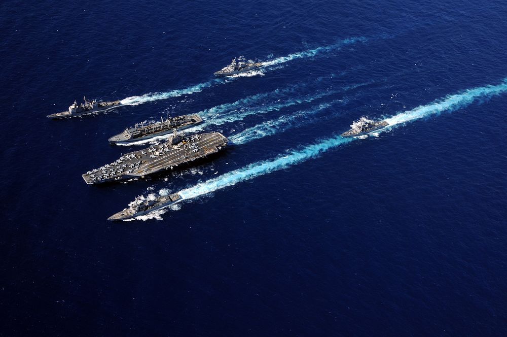 The aircraft carrier USS Abraham Lincoln (CVN 72), bottom center, and the Military Sealift Command fast combat support ship…