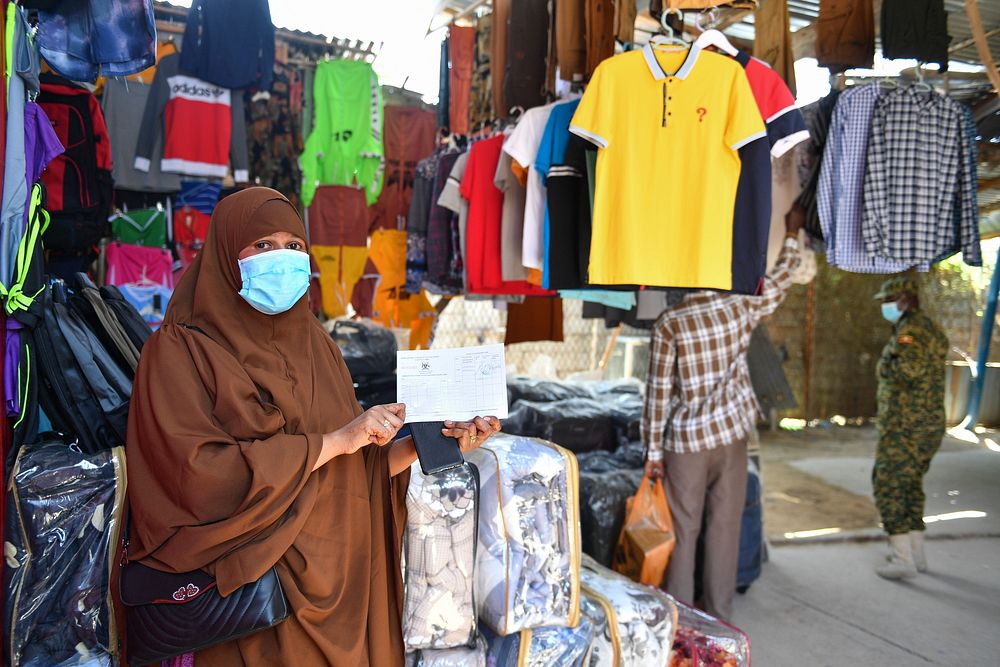 Shop owner holds out her COVID-19 certificate after getting the COVID-19 jab in Mogadishu, Somalia, on 30 August 2021.…