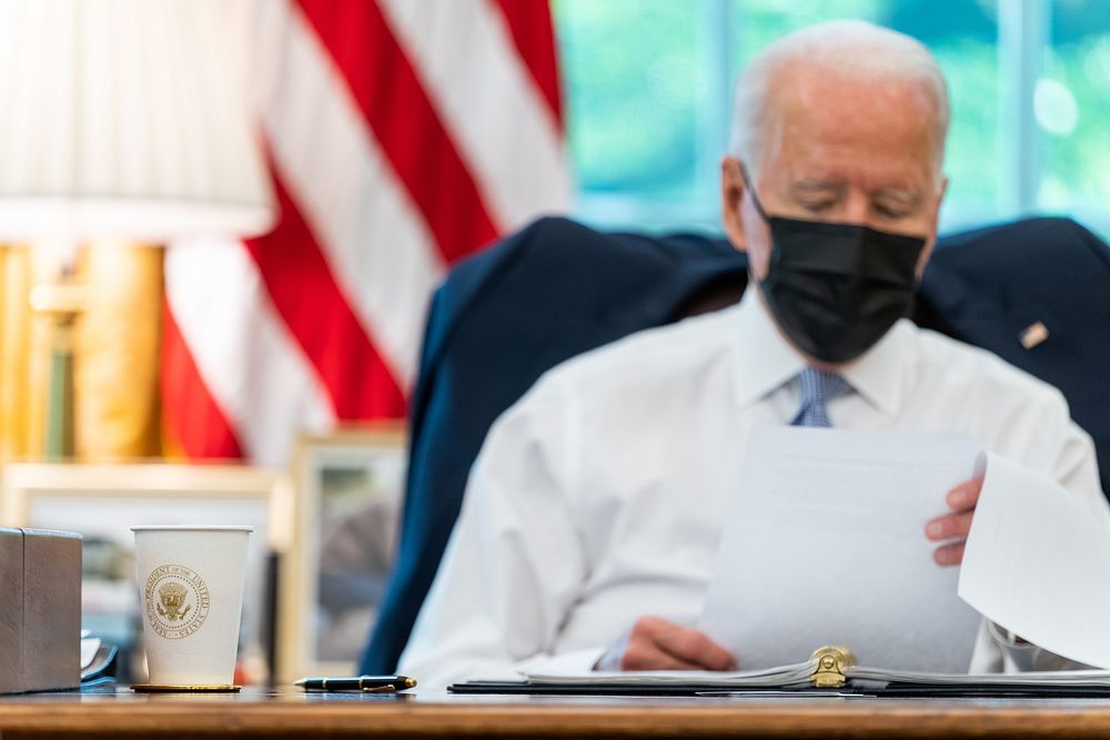 President Joe Biden looks over his notes in the Oval Office of the White House Thursday, July 29, 2021, prior to signing the…