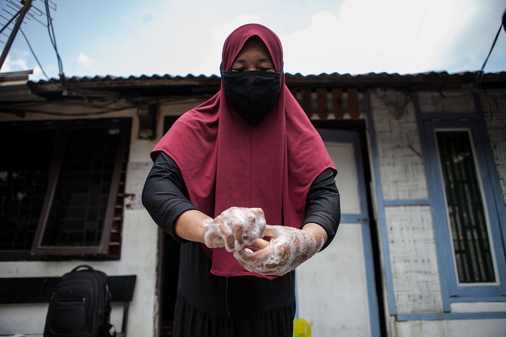 Woman washing hands with soap. Photo by: Andri Ginting for USAID. Original public domain image from Flickr