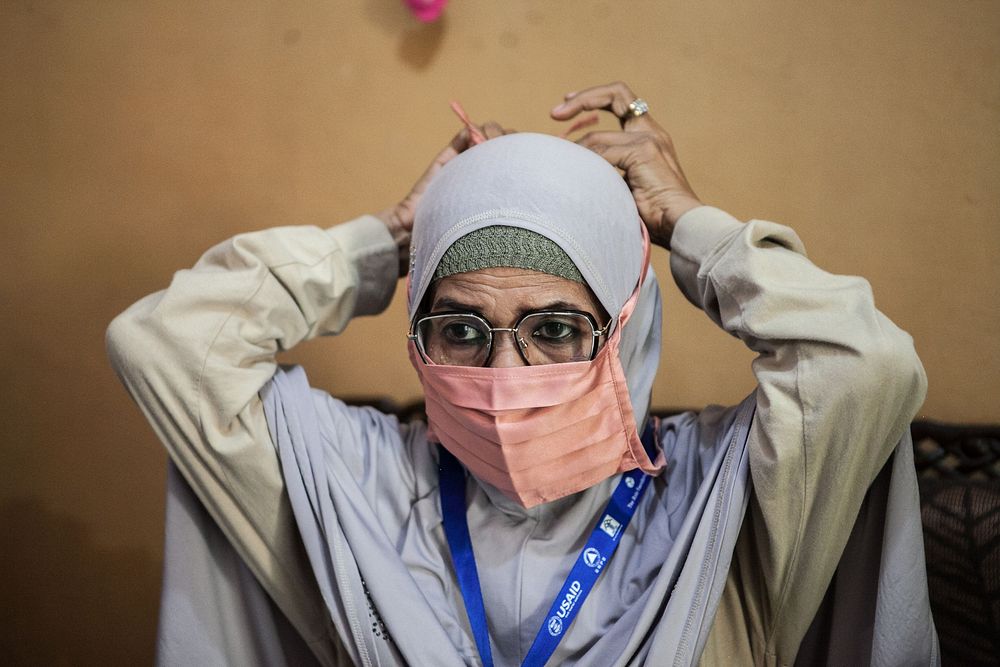 How to properly wear a mask.  Photo by: Andri Ginting for USAID. Original public domain image from Flickr