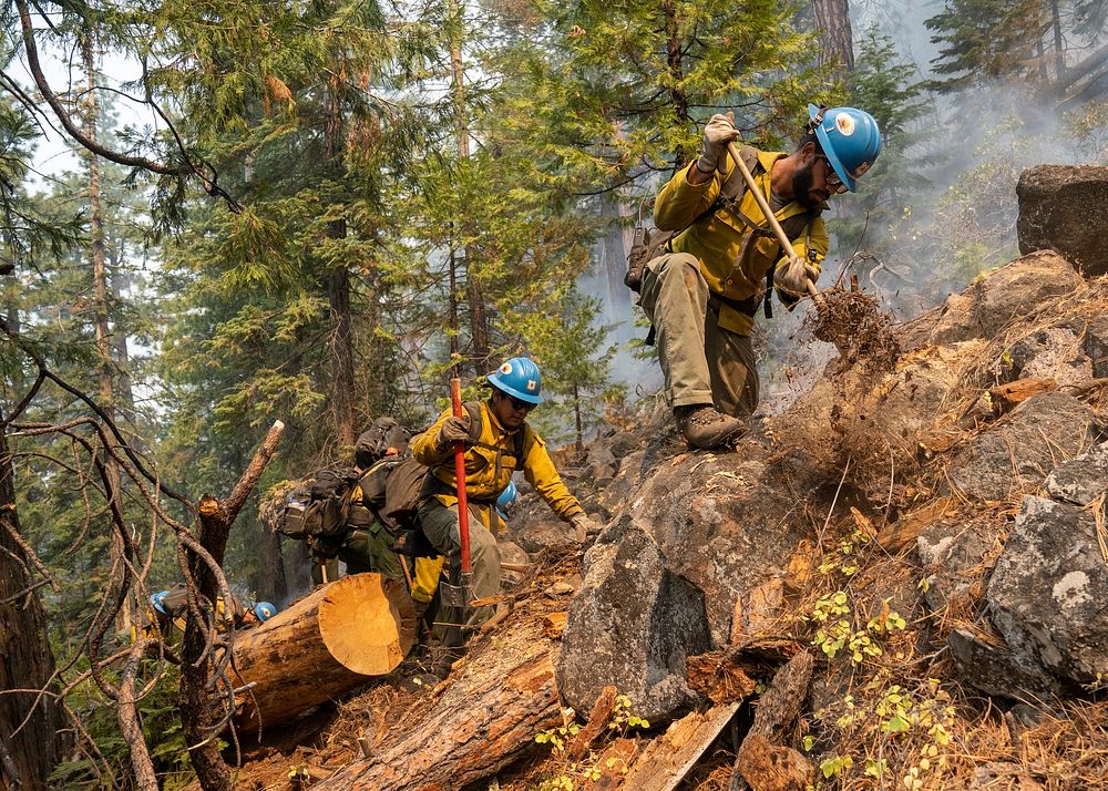 Blue Ridge Hot Shots dig a fireline on a steep-sloped mountain to suppress the Dixie Fire in Lassen National Forest…