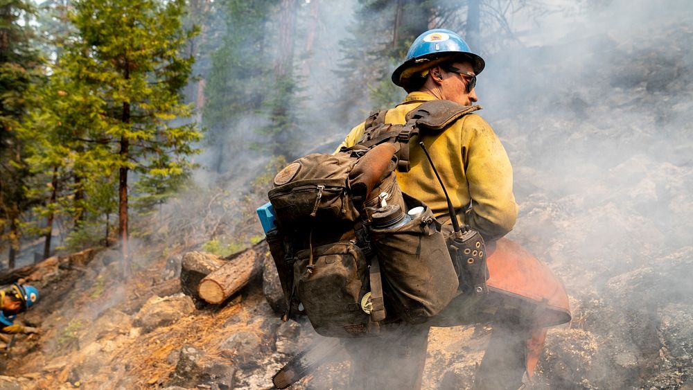 Blue Ridge Hot Shots cut trees and dig a fireline on a steep-sloped mountain to suppress the Dixie Fire in Lassen National…