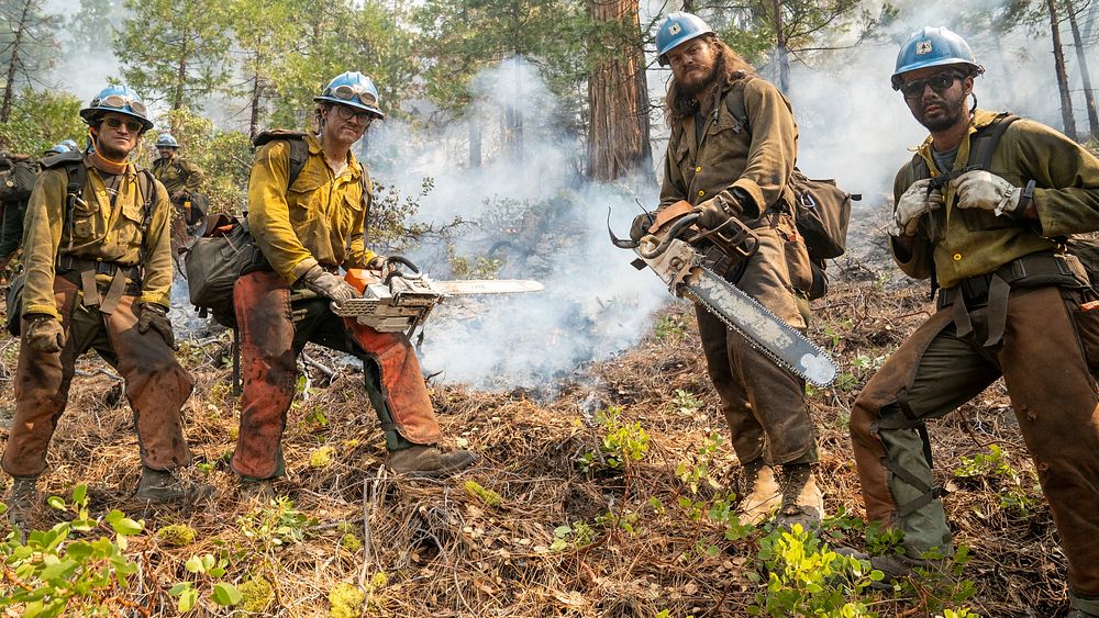 Blue Ridge and Plumas Hot Shots connect after completing a fire-suppressing fire line on a smoky steep-sloped mountain to…