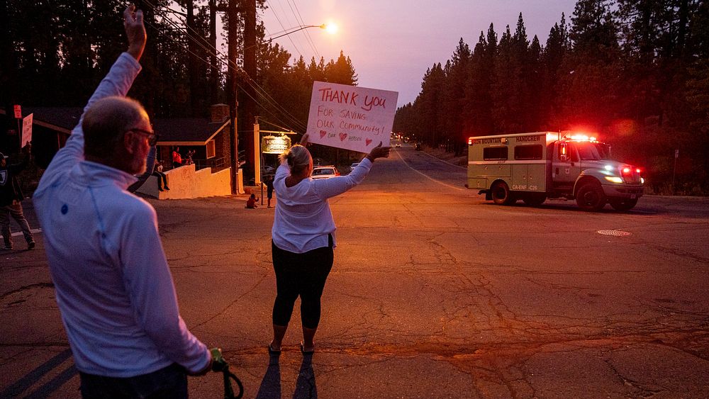 South Lake Tahoe locals cheer, yell and blow horns to thank the firefighters for their support in protecting their homes…