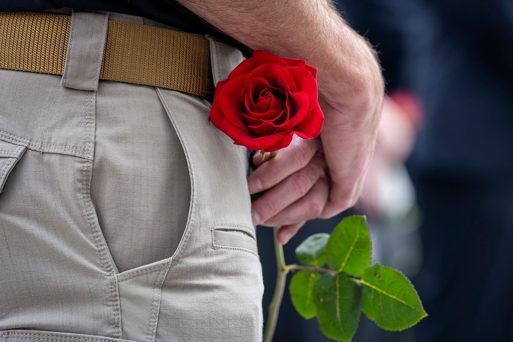Man holding red rose. Original public domain image from Flickr
