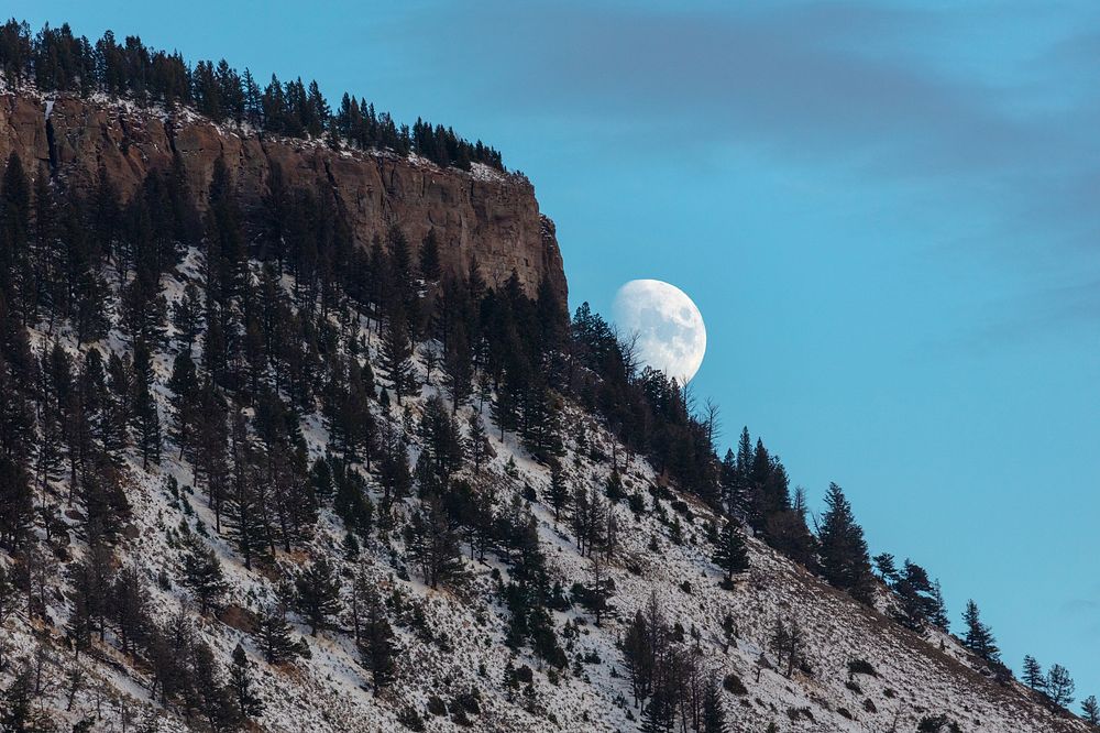 The moon rises over a snow-dusted Mt. EvertsNPS / Jacob W. Frank