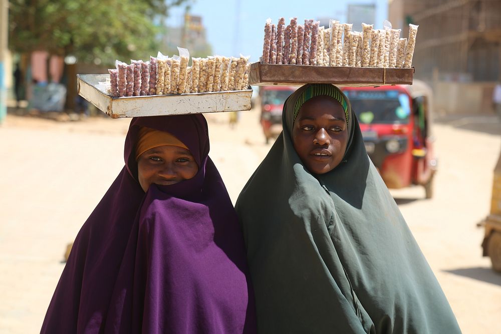 Girls selling snacks on the street. Original public domain image from Flickr