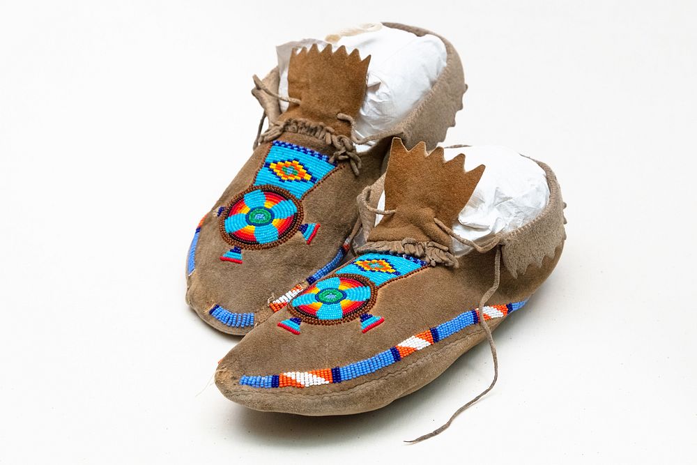 YELL 14750: moccasin (2)Pair of men's partially beaded moccasins with flaps around ankles and drawstring-type laces. Short…