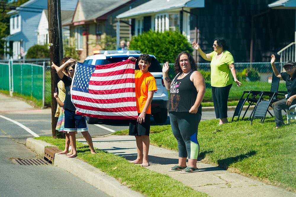 Residents wave as President Joe Biden's motorcade travels to the Somerset County Emergency Management Training Center in…
