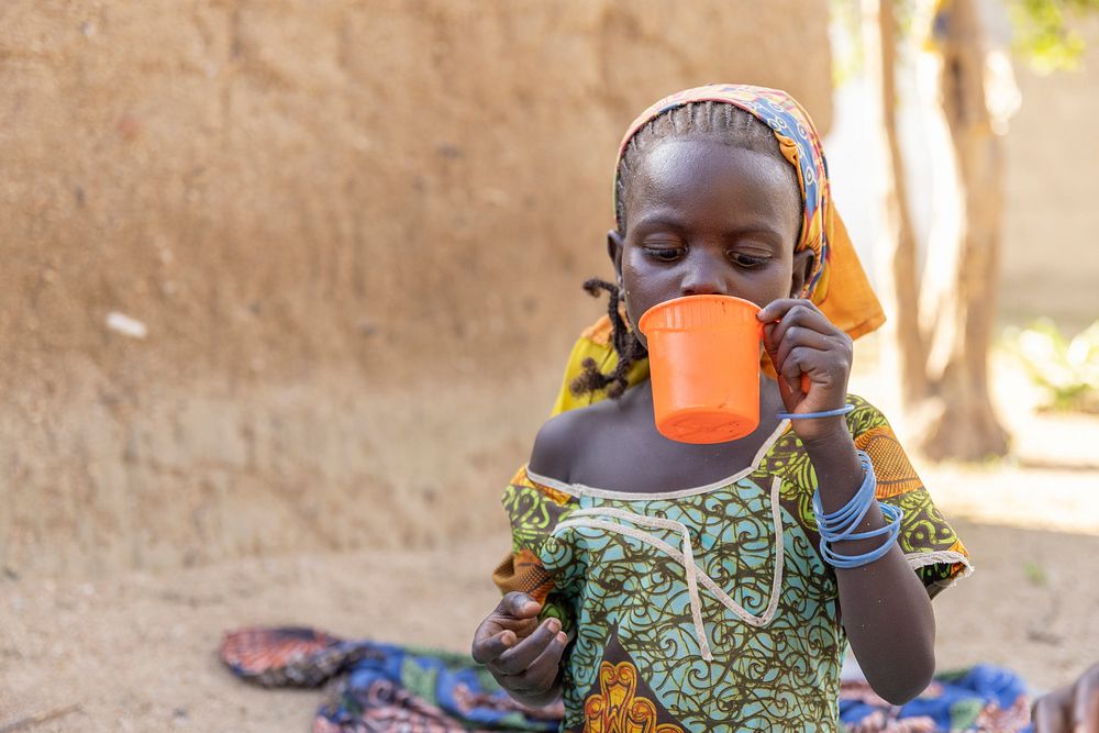 Child taking malaria medication at her family's home in Balaza, September 23, 2021. Original public domain image from Flickr