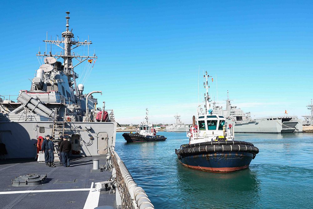 NAVAL STATION ROTA, Spain (Jan. 9, 2022) Tug boats pull away from the Arleigh Burke-class guided-missile destroyer USS Ross…