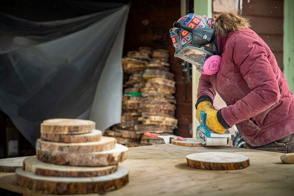 Tree "Cookies" are used to study climate changes over time.This image shows a person sanding a tree cookie outside a…