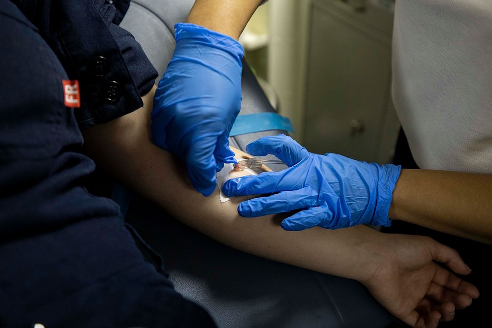 BRITISH ISLES. Hospital Corpsman 2nd Class Danica Laguardia, from Teaneck, N.J., right, administers an intravenous drip to…