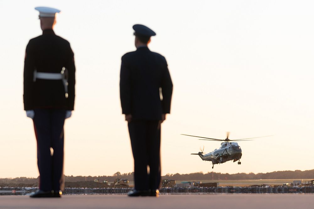 A U.S. Marine and U.S. Air Force personnel stand at attention as Vice President Kamala Harris aboard Marine Two prepares to…