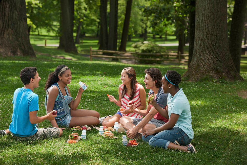 Teens eating at a summer meal site in a park. Original public domain image from Flickr