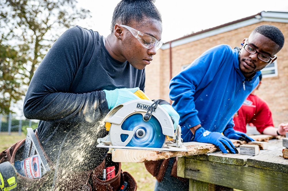 Students learning the basics of cutting with a skill saw, Greenville, 2-23. Original public domain image from Flickr