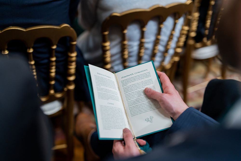 A guest consults a program while President Joe Biden delivers remarks at a Saint Patrick’s Day event, Thursday, March 17…