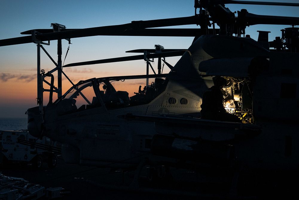 220715-N-TP544-1000 ATLANTIC OCEAN (July 15, 2022) A U.S. Marine performs maintenance on an AH-1Z Viper helicopter, attached…