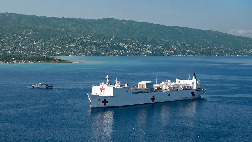 USCGC Kathleen Moore (WPC 1109) sails alongside the hospital ship USNS Comfort (T-AH 20) as it is anchored off the coast of…