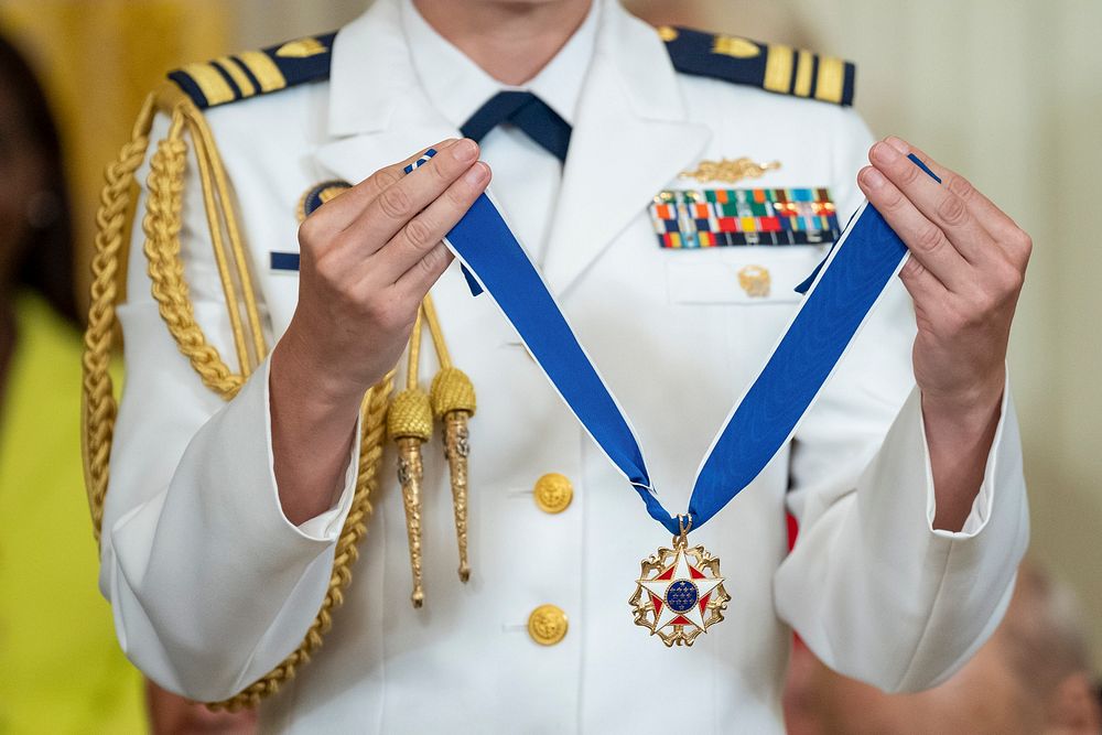 A military aide stands by while President Joe Biden presents the Medal of Freedom to Sister Simone Campbell, Thursday, July…