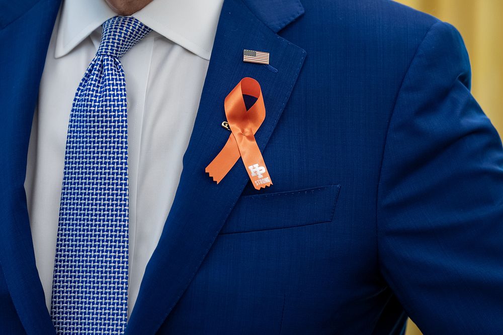President Joe Biden, wearing an orange ribbon for gun violence awareness, greets U.S. Senator Chris Murphy, D-Conn. and his…