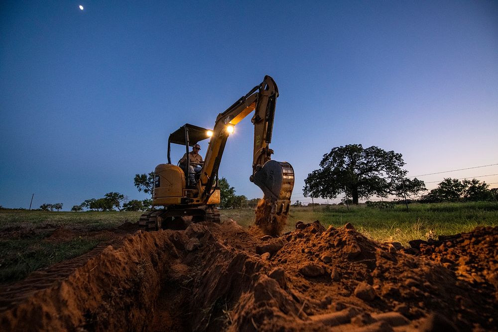 Stephen Thornhill trench into the evening to install livestock pipeline at the C.G. Merlo Ranch in San Saba, Texas, on June…