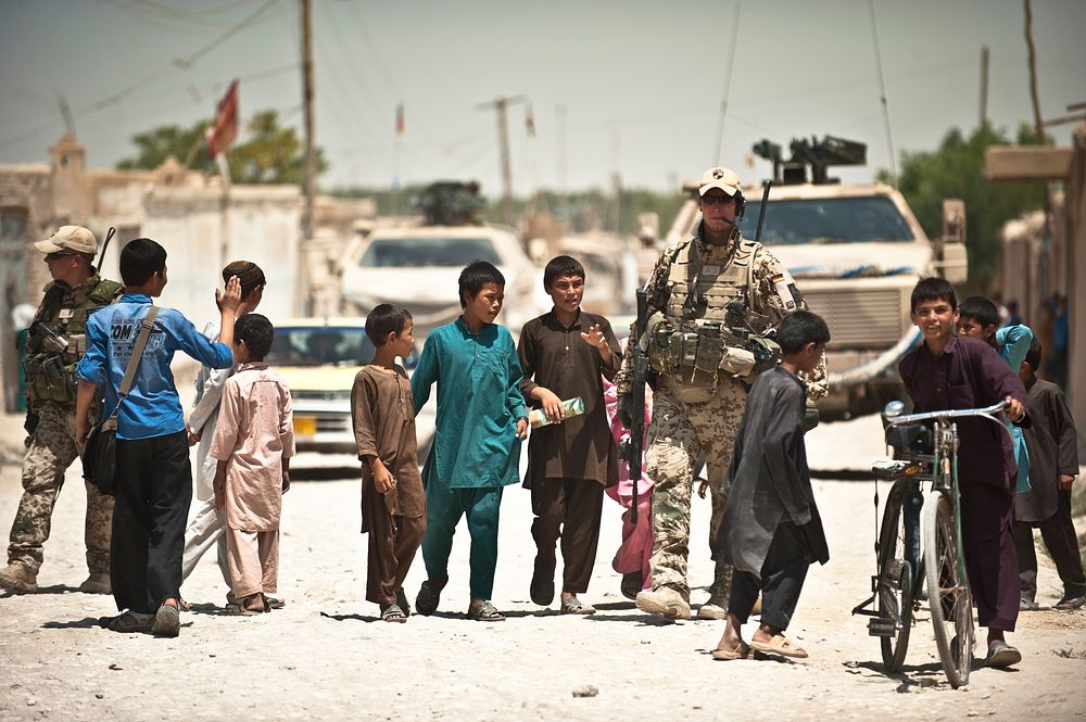 Afghan children accompany International Security Assistance Force soldiers during their patrol in Mazar-E Sharif.