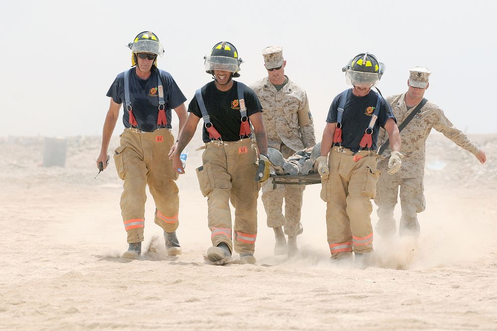 Emergency Services personnel at Camp Leatherneck, Afghanistan, treat a simulated casualty during a mass casualty evacuation…