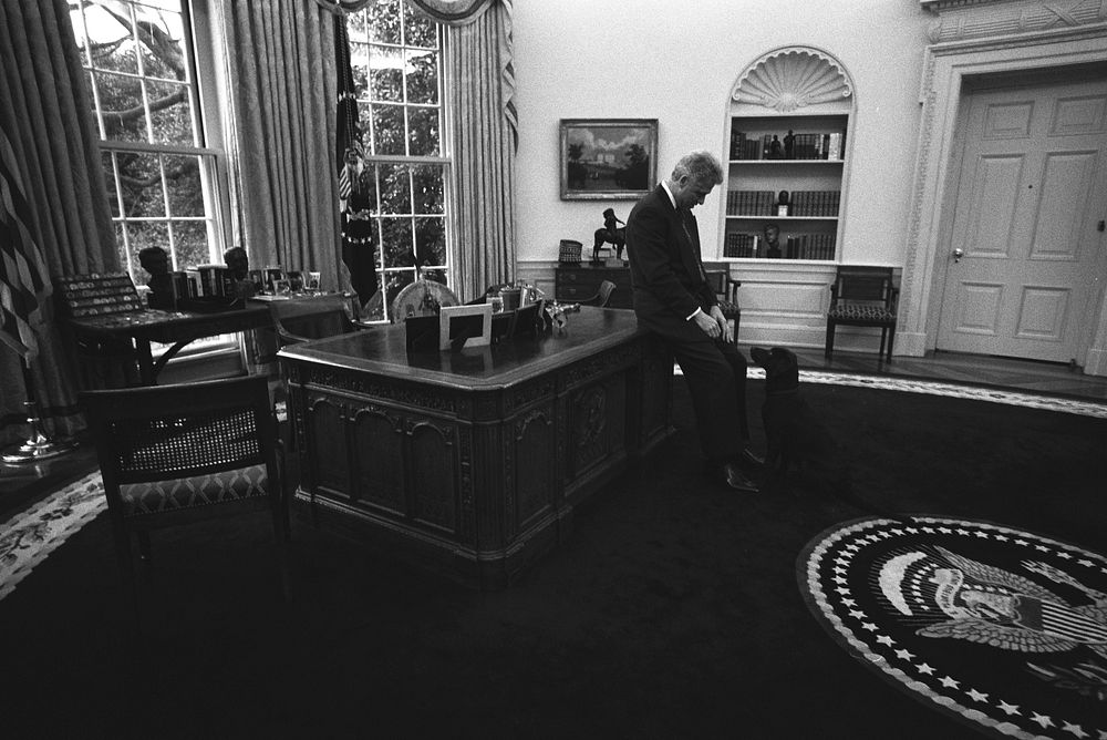Photograph of President William Jefferson Clinton with Buddy the Dog in the Oval Office: 01/16/1998. Original public domain…
