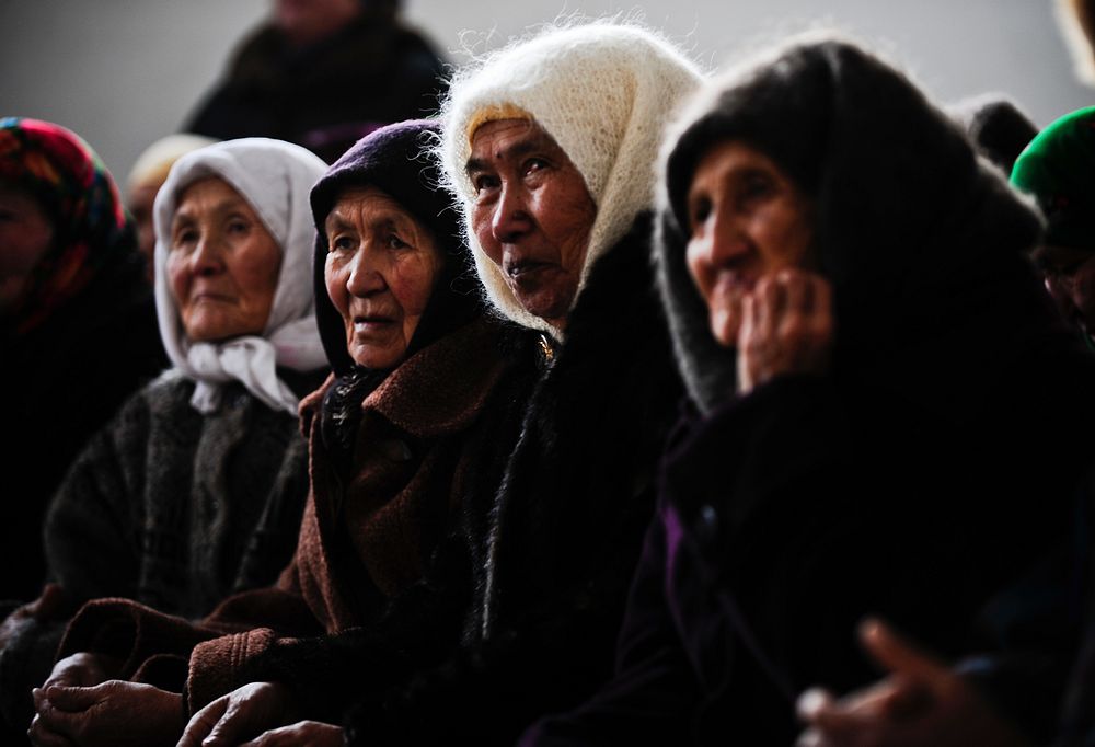 Kyrgyz women wait their turn to receive a winter coat in Emgekchil School gymnasium in Sary-Oi, Kyrgyzstan, Jan. 16, 2012…